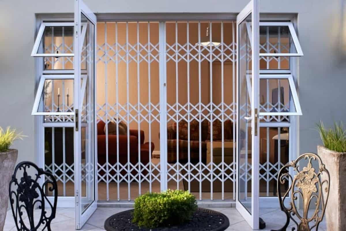 White trellis security gate installed across patio doors